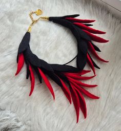 red and black feathered necklace on white fur