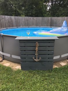 an above ground pool in the middle of a yard with grass and a wooden fence