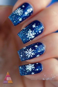 Stunning white snowflake nail design with navy blue background and glitter accents. These winter-inspired nails feature intricate white snowflakes set against a deep blue base adorned with shimmering glitter. Perfect for the colder months. Visit nailhow.com for more beautiful nail art inspiration. Christmas Nail Glitter Designs, Blue Sparkle Winter Nails, Marble Blue Nail Art, Winter Nails Ideas Blue, Snowflake Nail Design Blue, New Year’s Day Nails, Chrome Blue Nails Designs, Blue Snowflakes Nails