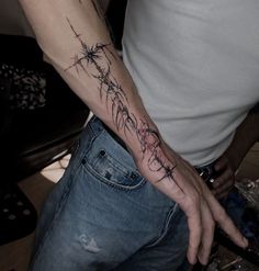 a man with a barbed wire tattoo on his arm