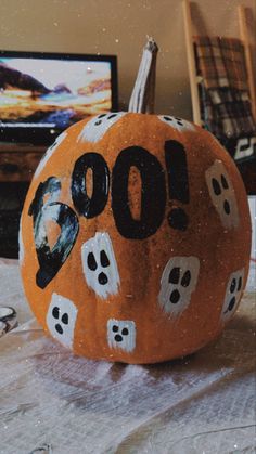 a painted pumpkin with the word boo spelled out in black and white letters on it