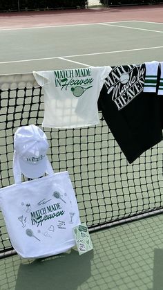 three shirts hanging on a tennis court net