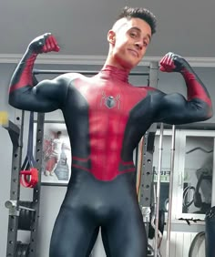 a man in black and red body suit posing for the camera