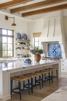 a large kitchen with an island in the middle and blue vases on the wall