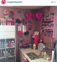 a room filled with lots of pink and zebra print decorations on the wall above a desk