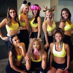 a group of women in sports bras posing for a photo with their tongue sticking out