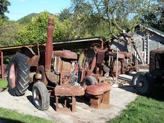 an old tractor sitting in the middle of a yard