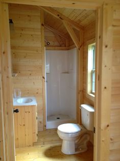 a bathroom with wood paneling and white fixtures