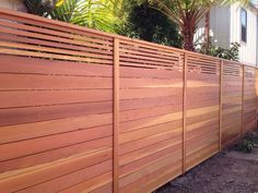 a wooden fence in front of some trees