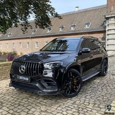 a black mercedes suv parked in front of a building