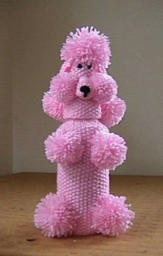 a pink teddy bear sitting on top of a wooden table