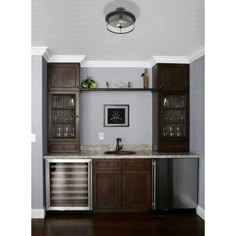 a kitchen with wooden cabinets and stainless steel dishwasher in the center, on top of a hard wood floor