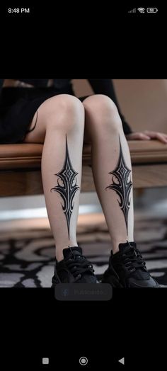 the legs and ankles of a woman with tattoos on them, sitting on a bench