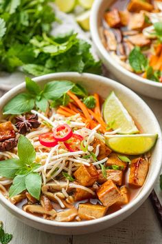 two white bowls filled with food and garnished with cilantro