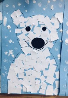 a polar bear made out of paper on a blue background with white snow flakes