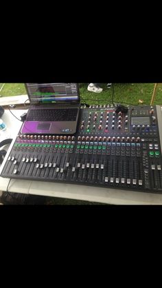 a laptop computer sitting on top of a sound mixing console