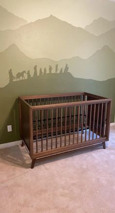 a crib in front of a wall with a nativity scene painted on it