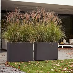 two large metal planters sitting in the grass