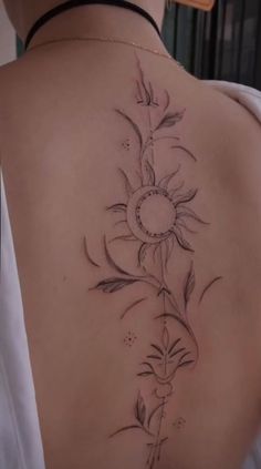 the back of a woman's shoulder with a sunflower tattoo on it