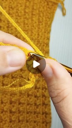 someone is knitting something with yellow yarn