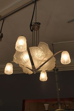 a chandelier with five lights hanging from it's sides in a room