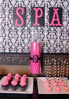 pink and black cupcakes are on the table