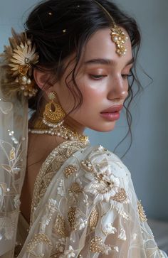 a woman in a white dress with gold jewelry on her head