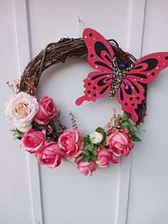 a wreath with flowers and a butterfly hanging on the front door to make a decoration