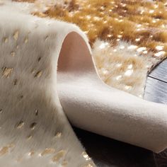 a close up of a rug on the floor with gold and white dots all over it