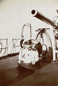 an old photo of a man sitting in a chair on the deck of a ship