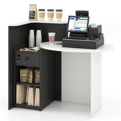 an office desk with a laptop and printer on it, next to some coffee cups