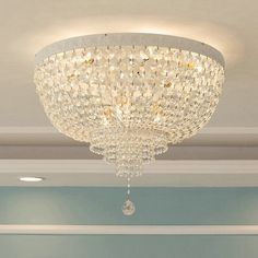 a chandelier hanging from the ceiling in a room with blue walls and white trim