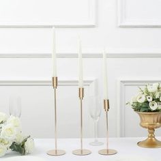 three candles are sitting on a table with white flowers