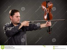 a man holding a violin in his hands and looking at the camera with an intense look on