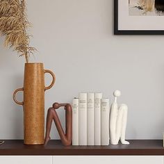 a shelf with books and vases on it