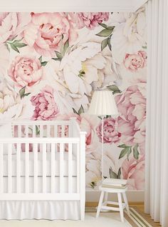 a white crib in front of a floral wallpapered nursery with pink flowers