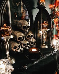 there are many skulls and candles on the table