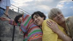 three people are hugging each other while one person is standing on the stairs behind them