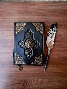 a book with a feather resting on top of it next to a pen and quill