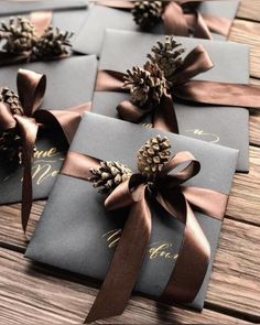 four wrapped gift boxes with pine cones on them