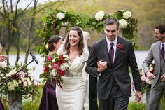 a bride and groom walk down the aisle at their outdoor wedding ceremony, surrounded by other guests