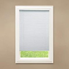 a white window with blinds on the side of it in front of a brown wall