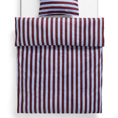 a red and white striped bed spread with two pillow cases on top of each other