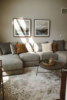 a living room filled with lots of furniture and pictures on the wall above it's couch