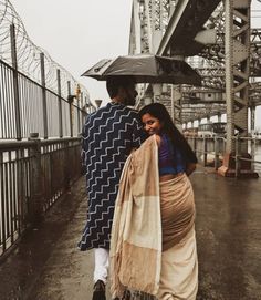 two people walking down the street with an umbrella