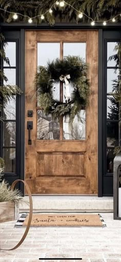 a front door decorated with christmas wreaths and lights