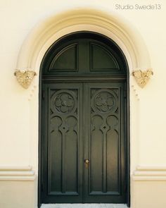 the front door to an old building with ornate ironwork and arched doorways on either side