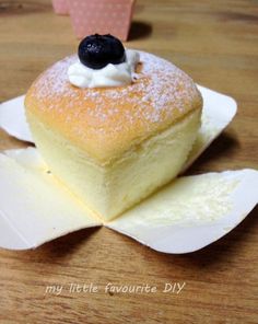 a piece of cake sitting on top of a white plate with powdered sugar and blueberries