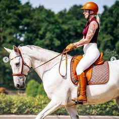 a woman riding on the back of a white horse