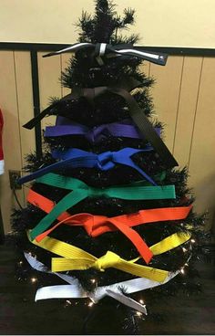 a decorated christmas tree with ribbons on it's sides and an arrow at the top